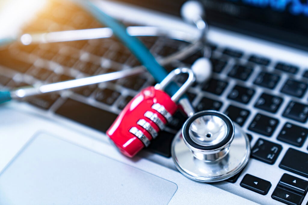 Stethoscope and padlock on a laptop representing ObamaCare marketplace fraud